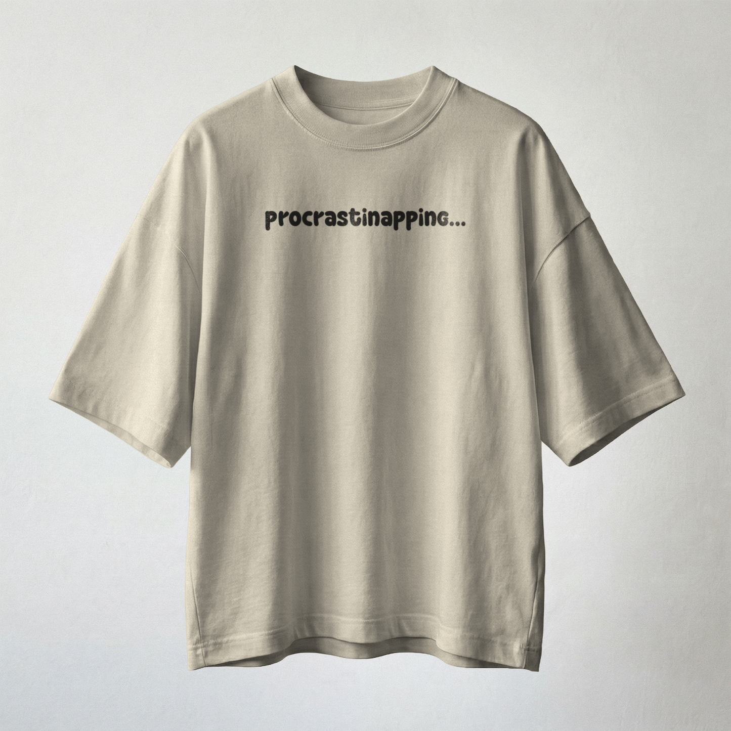 Beige oversized t-shirt front view minimal design with procrastinapping text