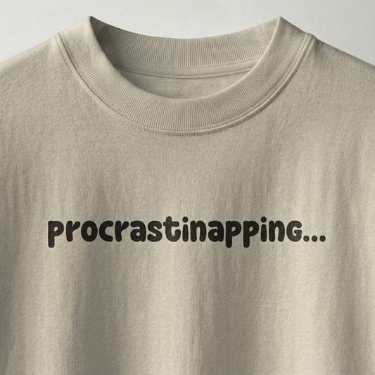 Beige oversized t-shirt with “procrastinapping” text printed in minimal playful font