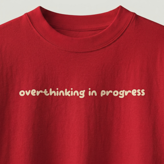 Close-up of “overthinking in progress” text on red oversized t-shirt