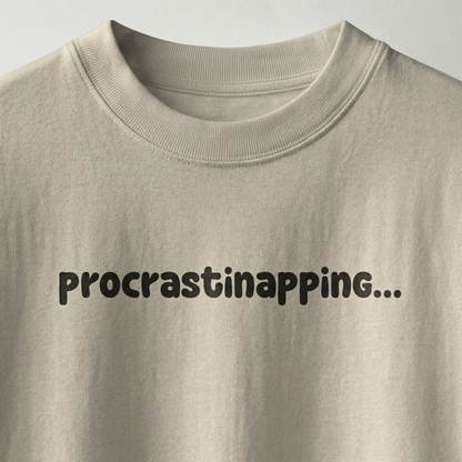 Beige oversized t-shirt with “procrastinapping” text printed in minimal playful font