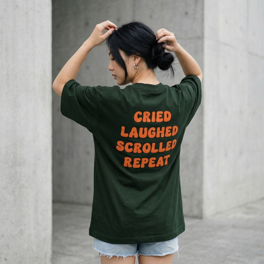Woman wearing dark green oversized t-shirt with bold orange text back casual street look