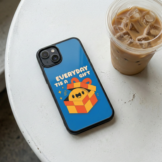 Everyday Is A Gift blue glass iPhone case by Spiritual Kalakaar placed on white cafe table beside iced coffee