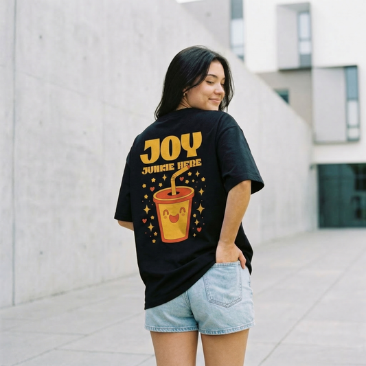 Woman wearing black oversized t-shirt with “Joy Junkie Here” back print