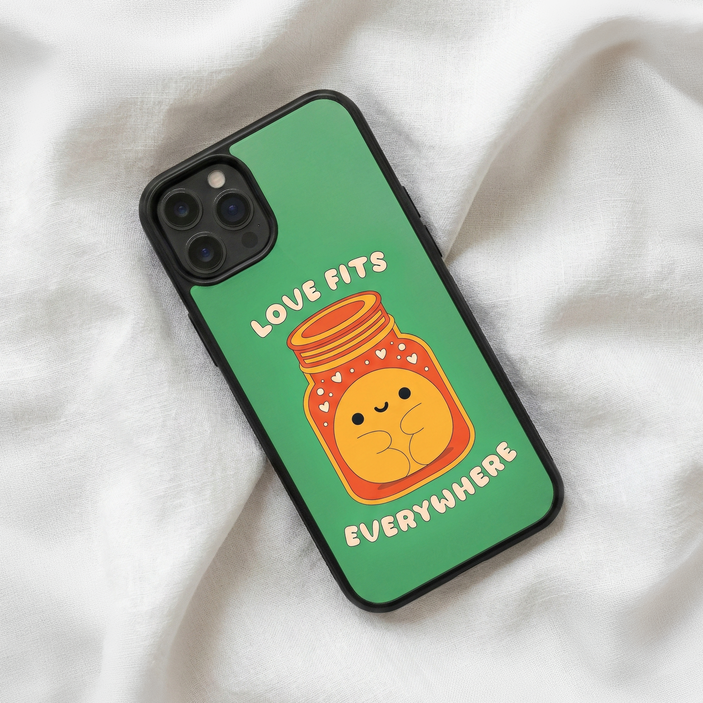 Love Fits Everywhere green glass iPhone case by Spiritual Kalakaar with cute jar illustration placed on soft fabric background