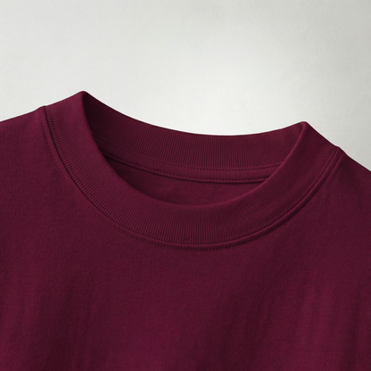 Close-up of maroon oversized t-shirt fabric and neckline showing soft cotton texture and stitching