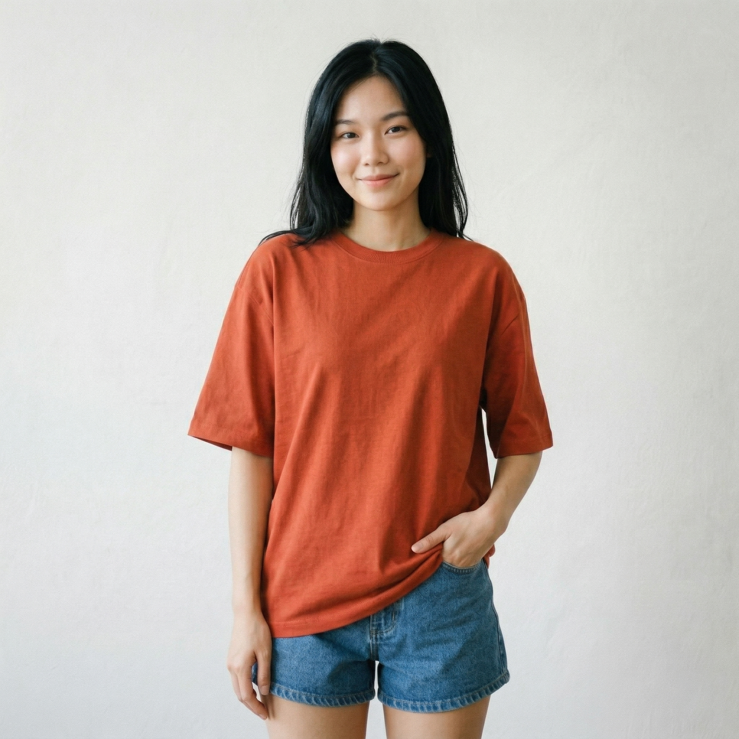 Woman wearing rust orange oversized t-shirt front view relaxed fit casual minimal style