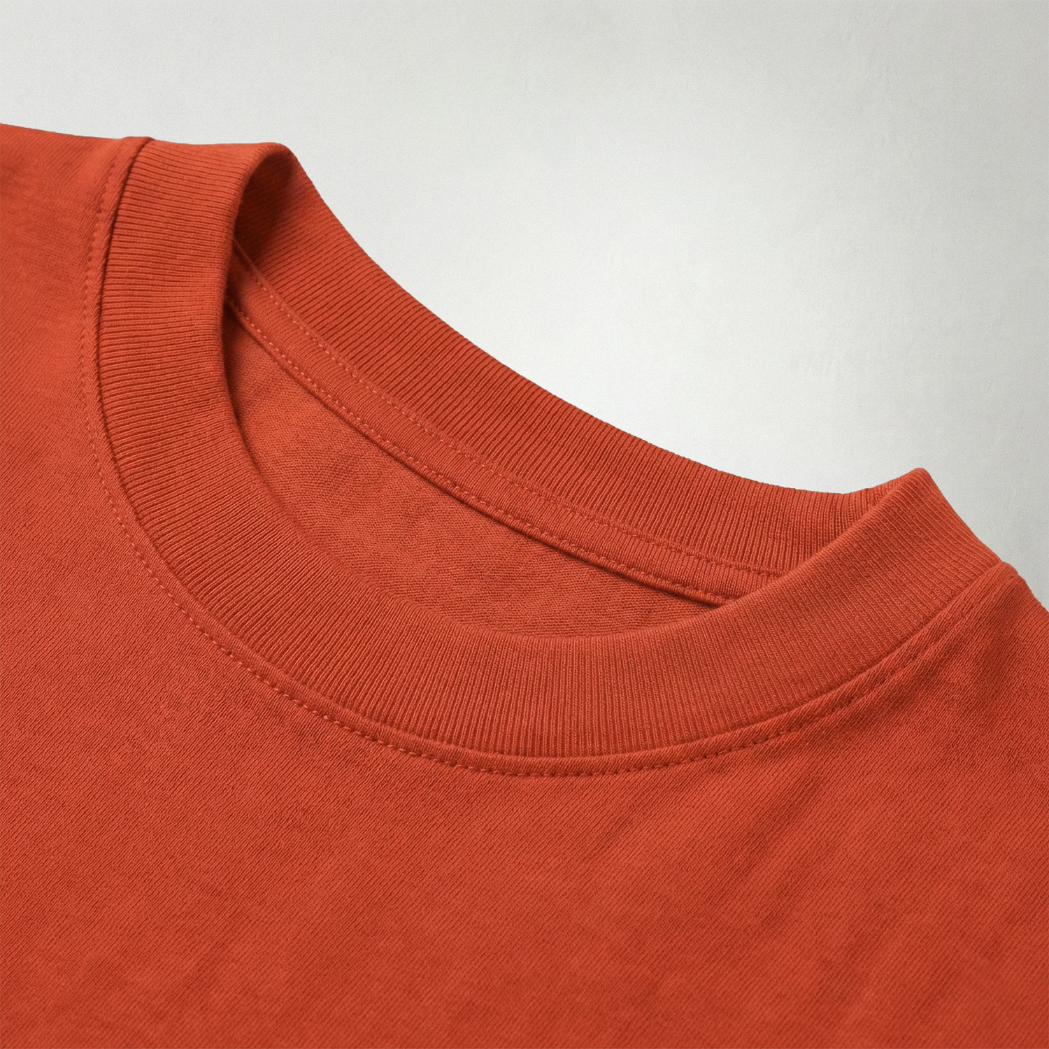 Close-up of rust red oversized t-shirt ribbed cotton collar stitching